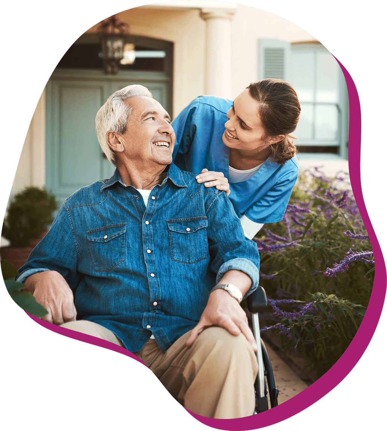 Elderly man in wheelchair with caregiver smiling.