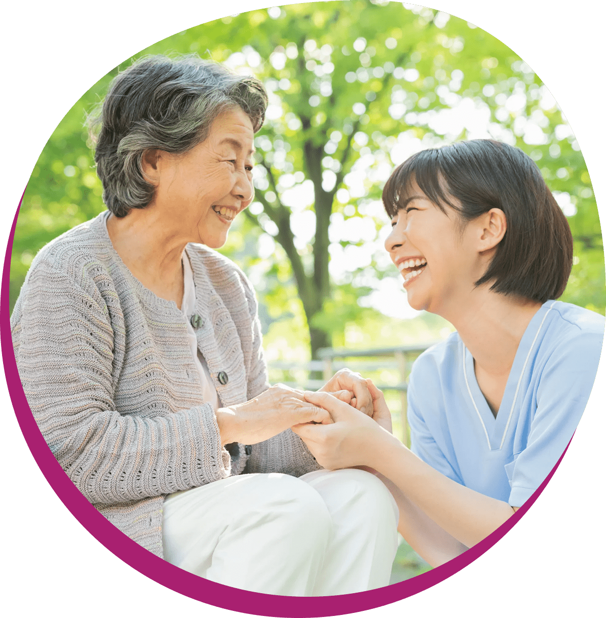 Elderly woman and caregiver smiling outdoors.