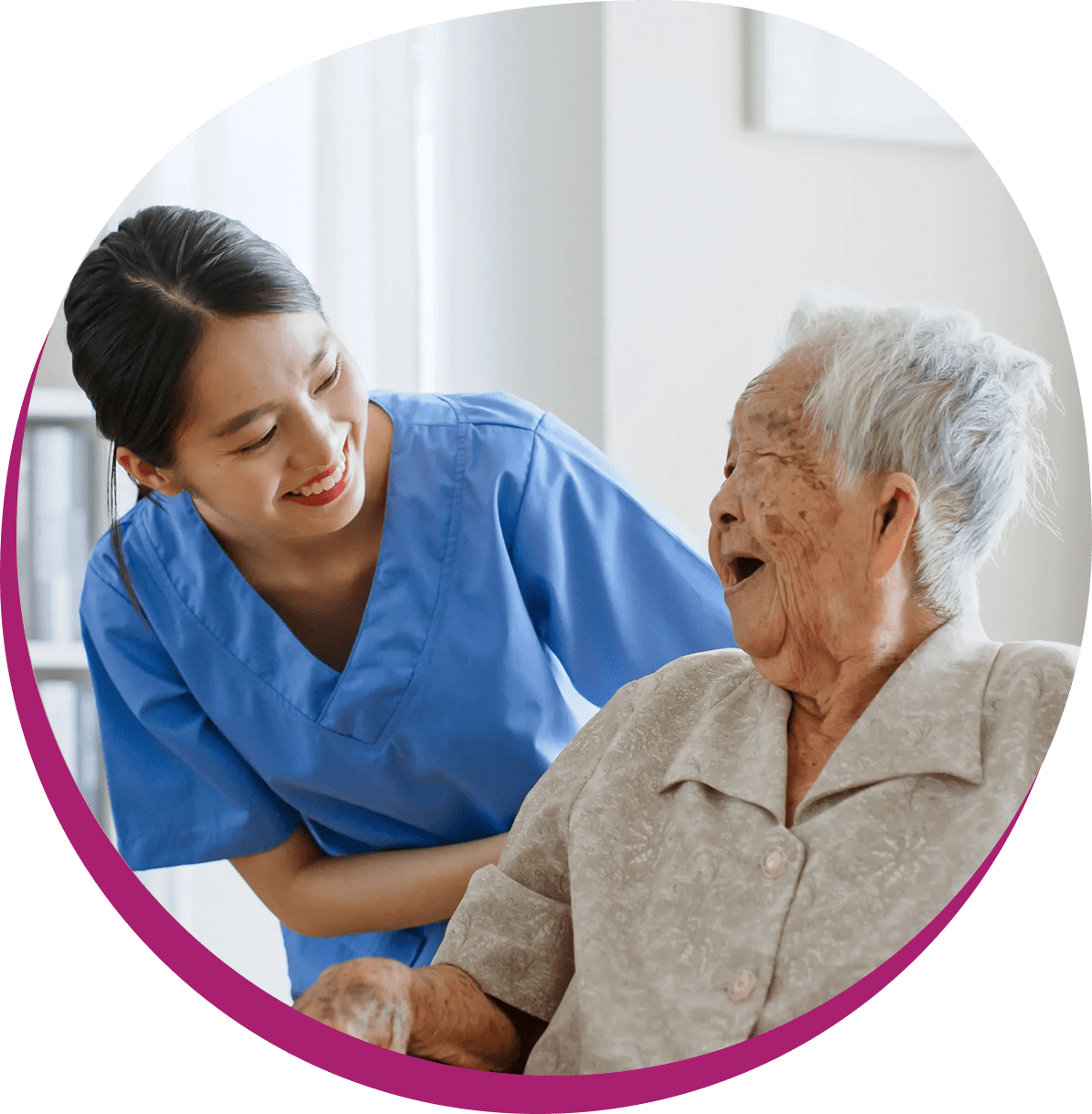 Caregiver smiling at elderly woman indoors.